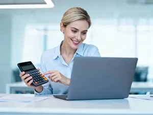 Mężczyzna pracujący przy laptopie z wykresami finansowymi w nowoczesnym biurze domowym.